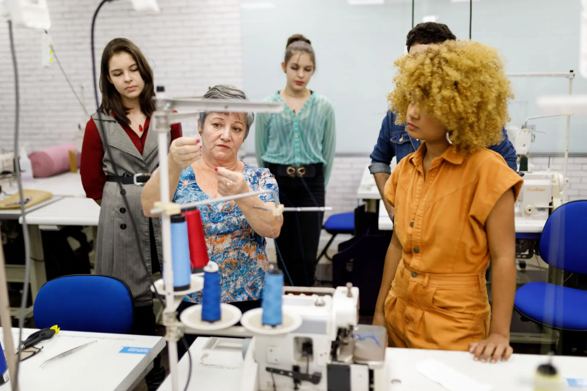 Women collaborating on a sewing project in a workshop.